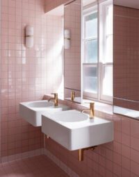 Natural Brass basin tapware with twin wall-mounted basins in a pink tiled bathroom